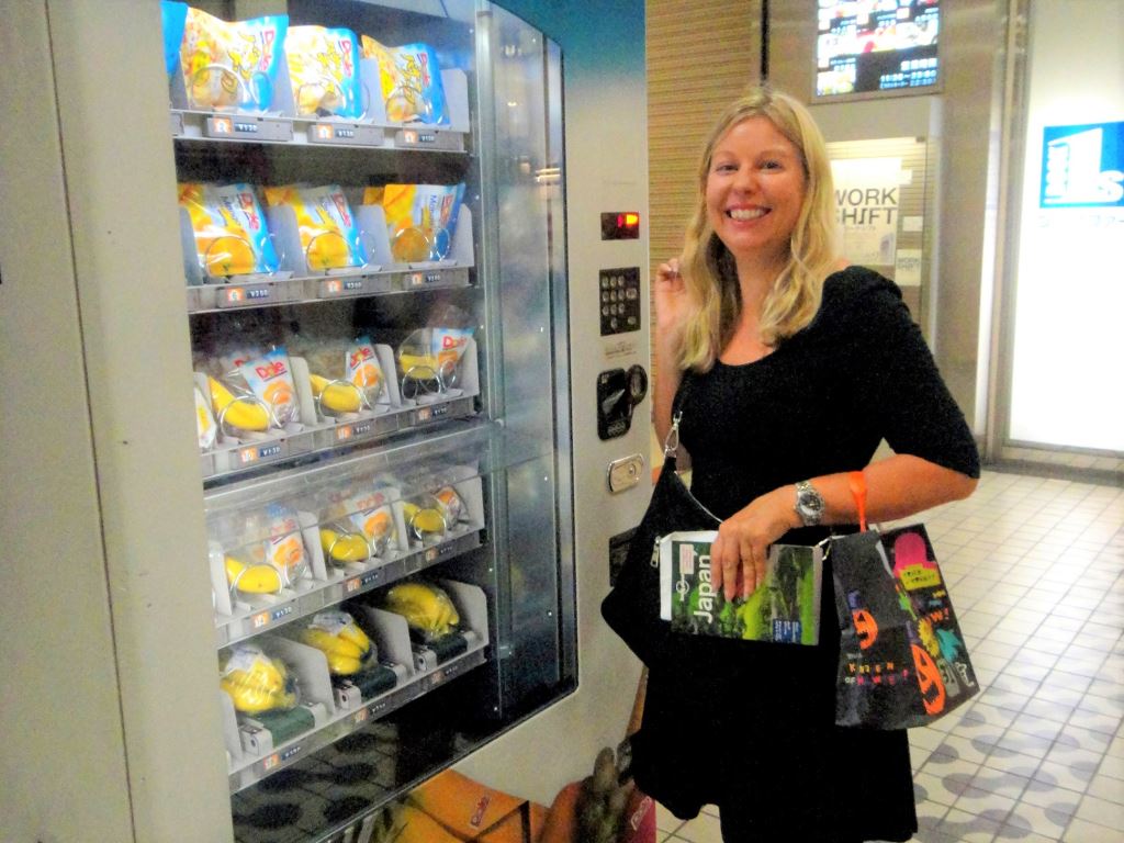 Helen from Japlanease stands by the banana vending machine in Shibuya, Japan. Unusual vending machines are on of the small things not to miss in Japan.