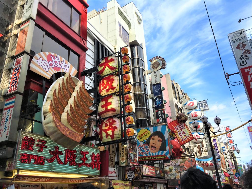 View of Dotonbori in Osaka showing street decorations like giant Gyoza stuck on buildings.
