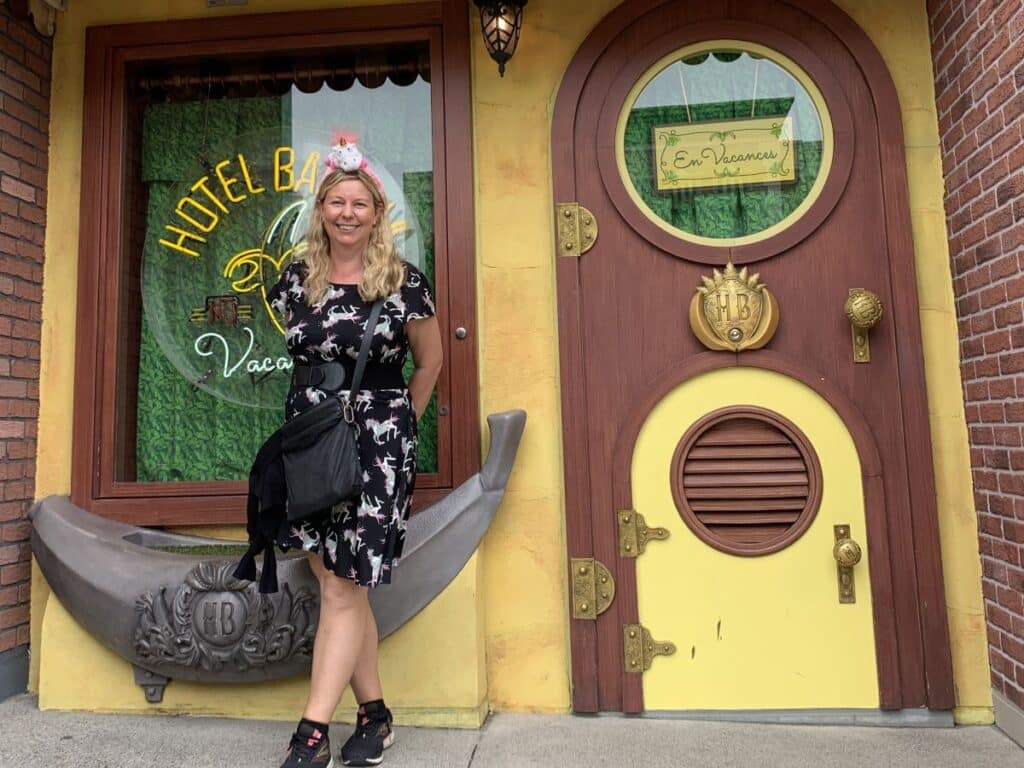 Helen from Japlanease stands in Minion Park at USJ wearing a fluffy unicorn headband