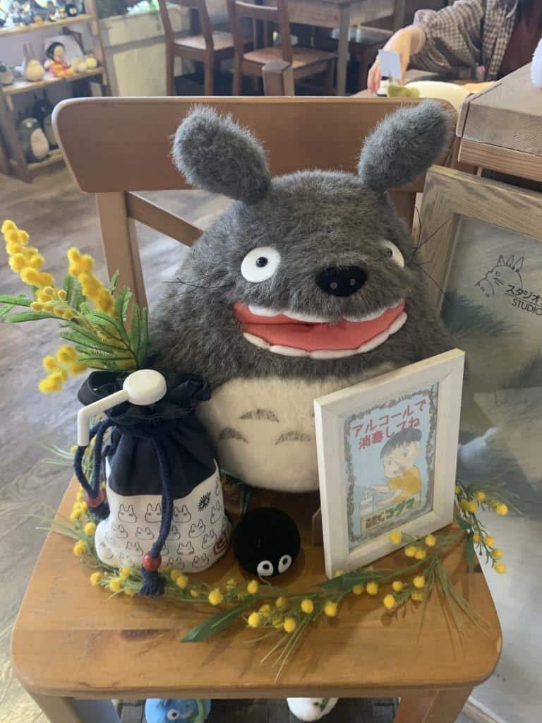 Giant stuffed Totoro from My Neighbour Totoro sites on a chair at Kodama Ghibli-inspired cafe in Nagoya