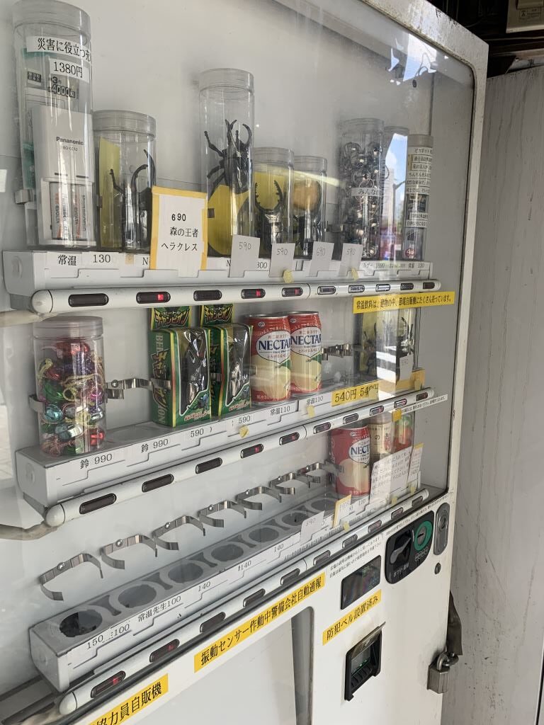 Vending machine in Akihabara Japan containing strange plastic insect toys and Peach nectar drinks