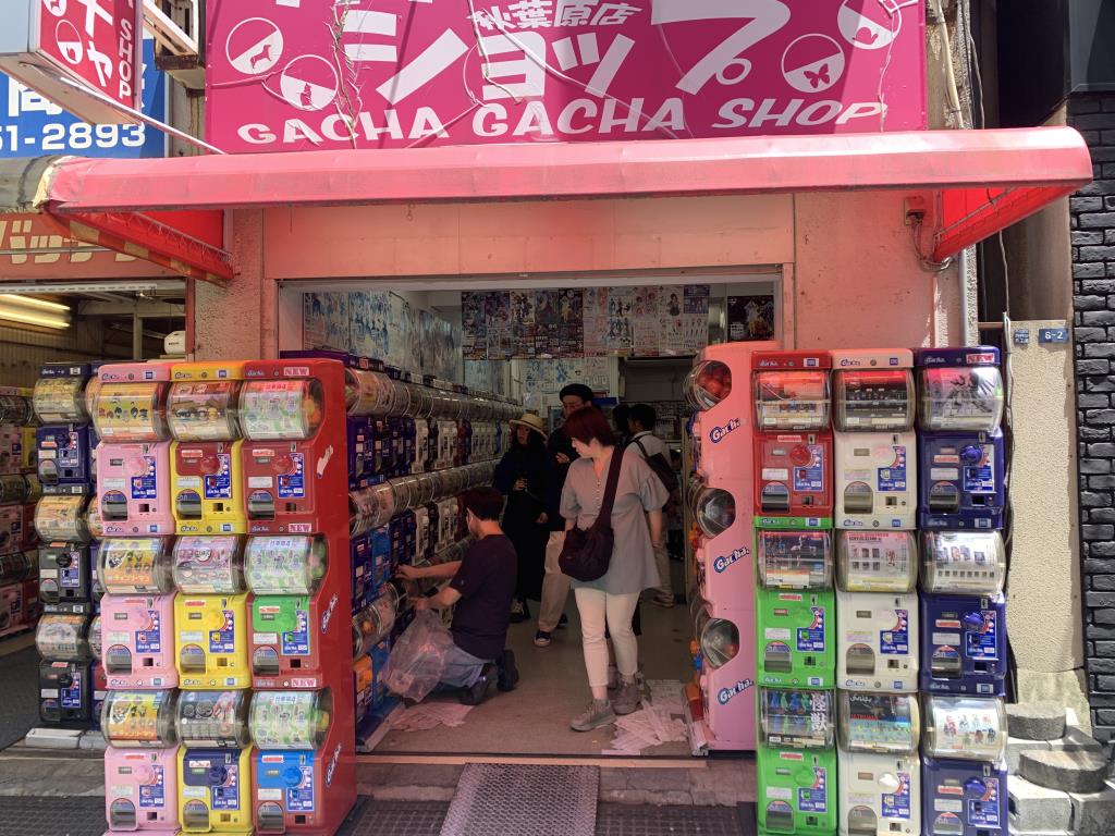 Gachapon capsule toy shop in Akihabara. The inside and outside is lined with capsule toy machines. It's sign reads gacha gacha shop.