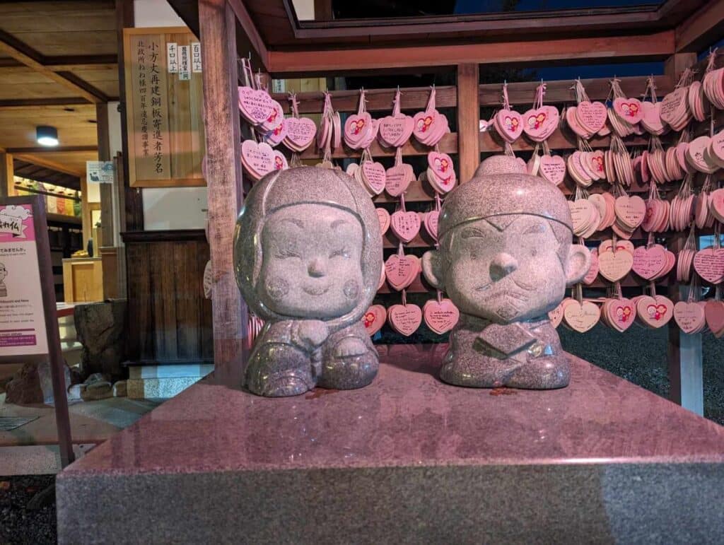 Two cute male and female statues at a shrine in Kyoto - part of the lucky statues walk.