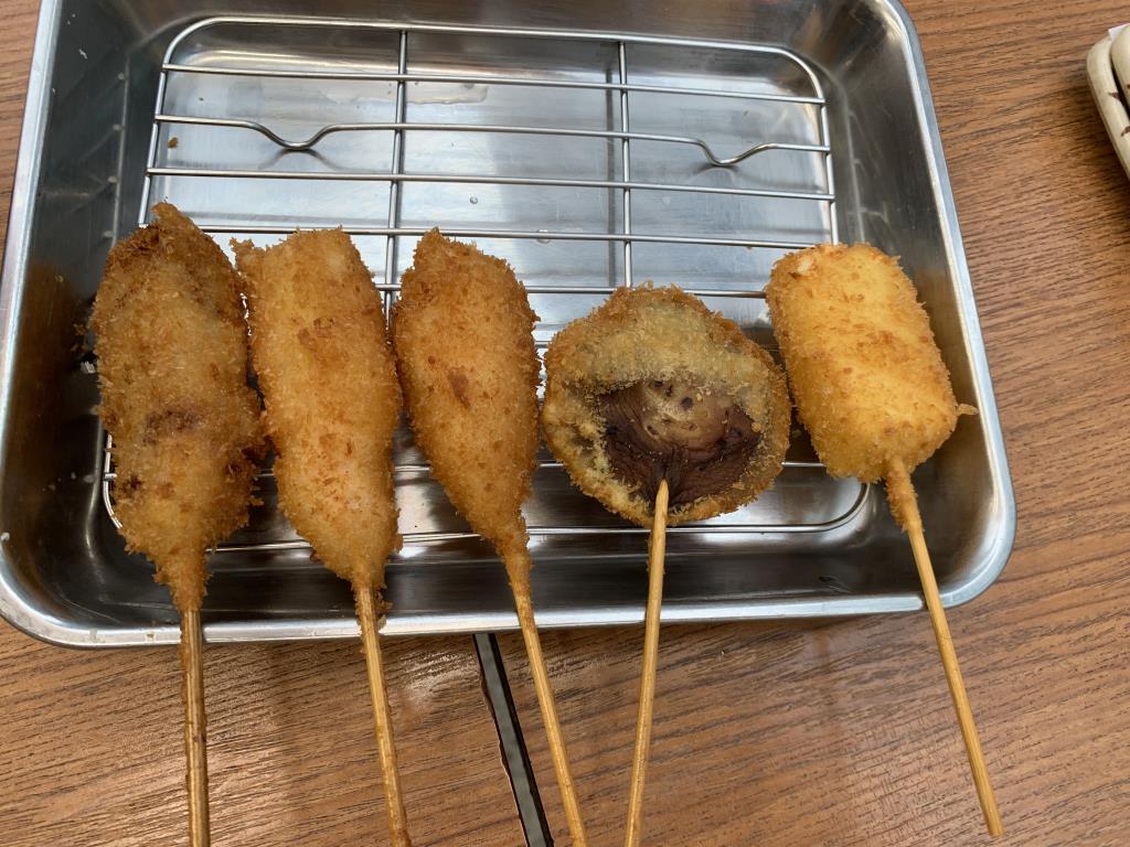 Sticks of kushi katsu sit on a metal tray.