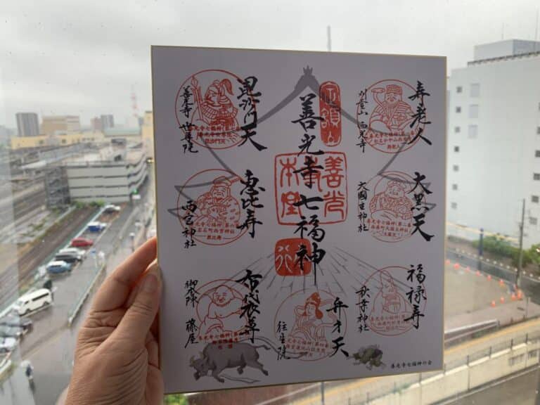 Completed sheet of stamps from the seven lucky gods walk in Nagano. It shows eight different red stamps each with a drawn image of each god.