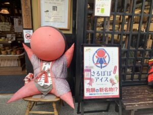 red sarubobo doll outside a shop in Takayama