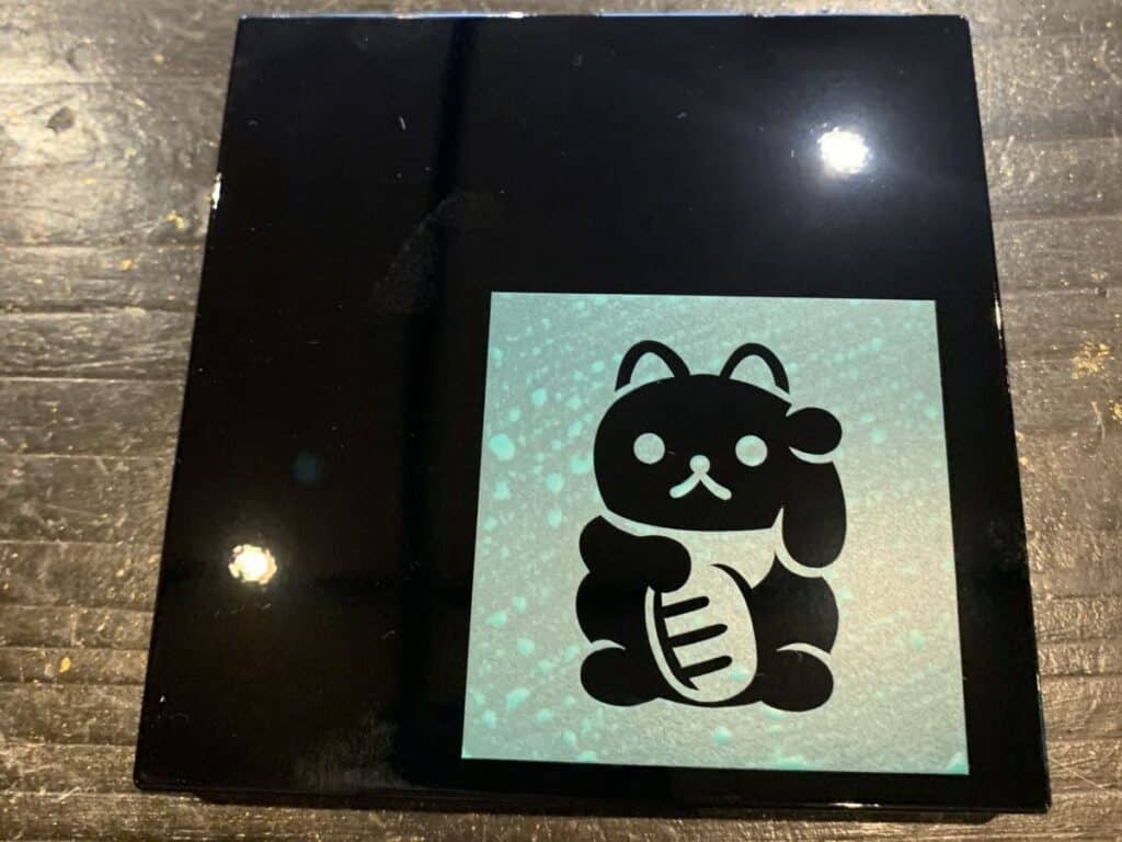 Stencil applied to a black box ready to have gold leaf added in Kanazawa