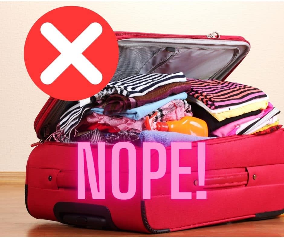 packed suitcase with a red cross and the word 'nope' written on it