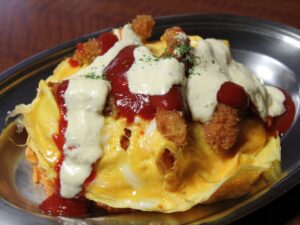 plate of hanton rice showing the egg topping, fried fish and ketchup and tartar sauce