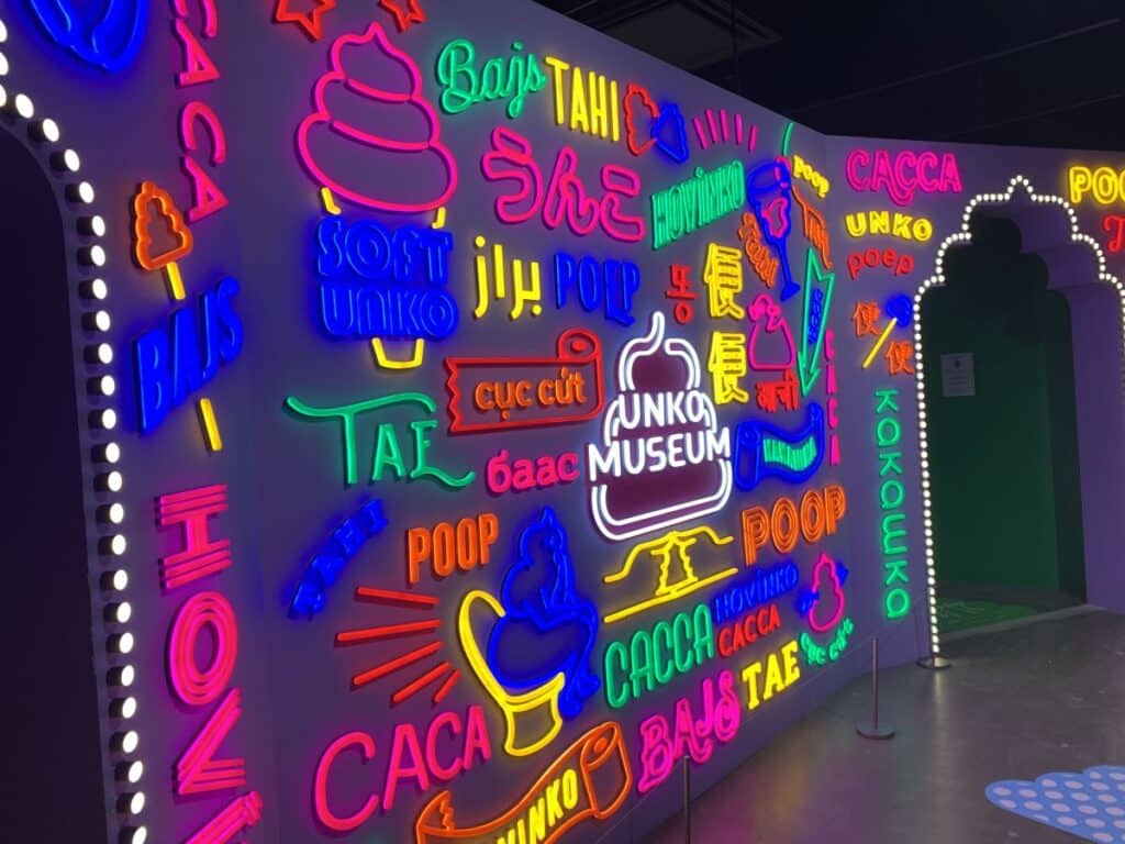 Wall of neon signs spelling out the words for poop in multiple languages at the Unko Museum in Tokyo