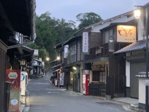Street in Miyajima at dusk showing lit up cafes and restaurants