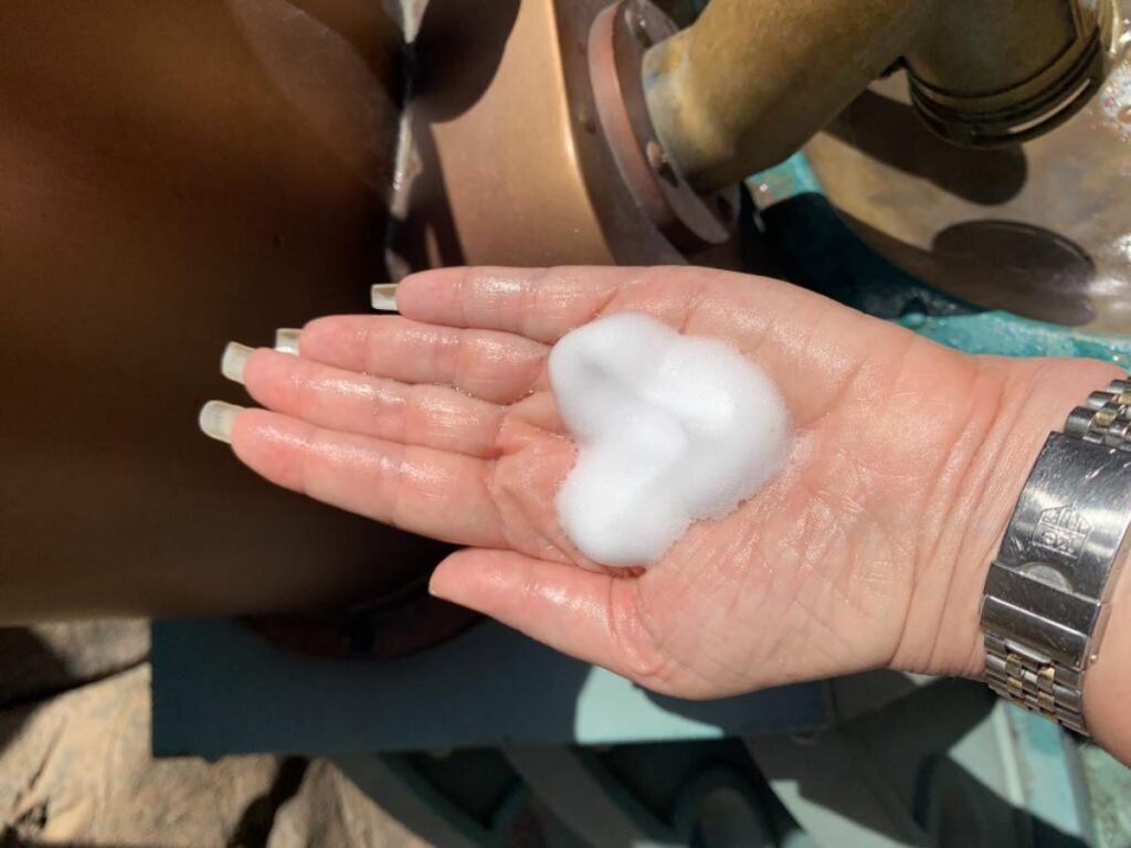 A blob of soap foam on a hand is shaped like Mickey Mouse