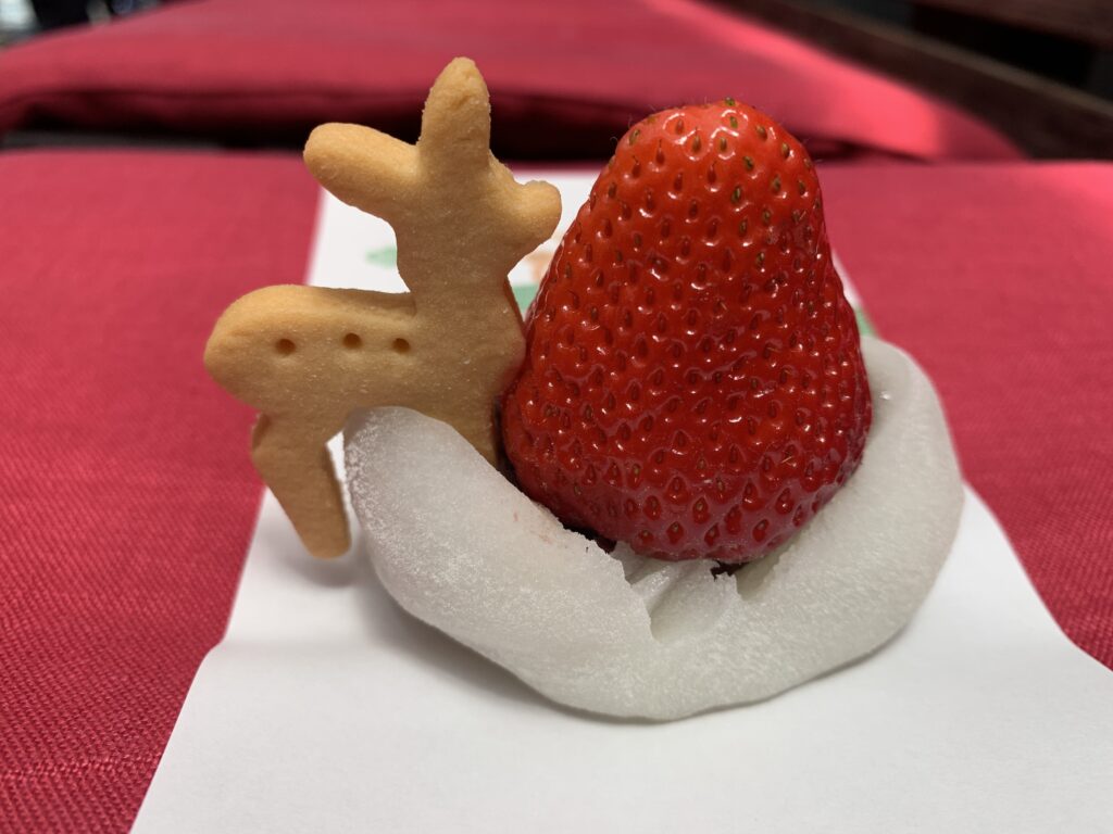 White daifuku topped with a strawberry and a deer shaped cookie