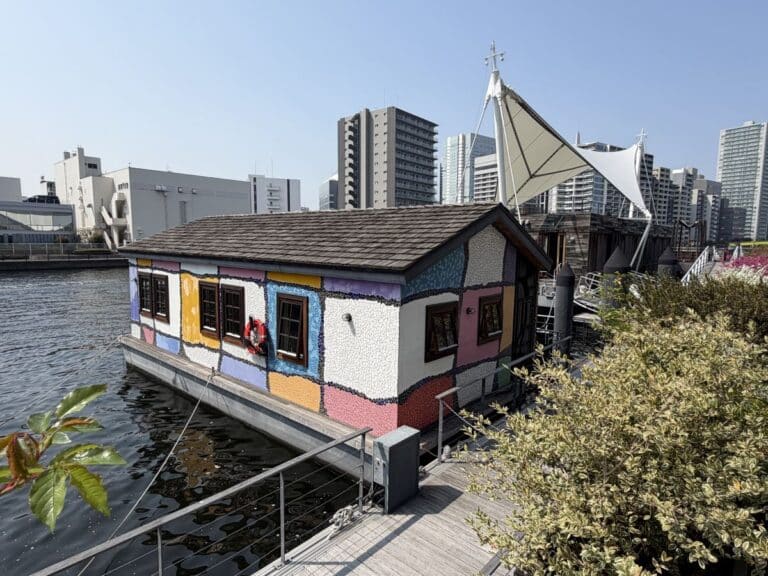 Houseboat style room at Petals Hotel in Tokyo. It floats on the water with skyscrapers behind it