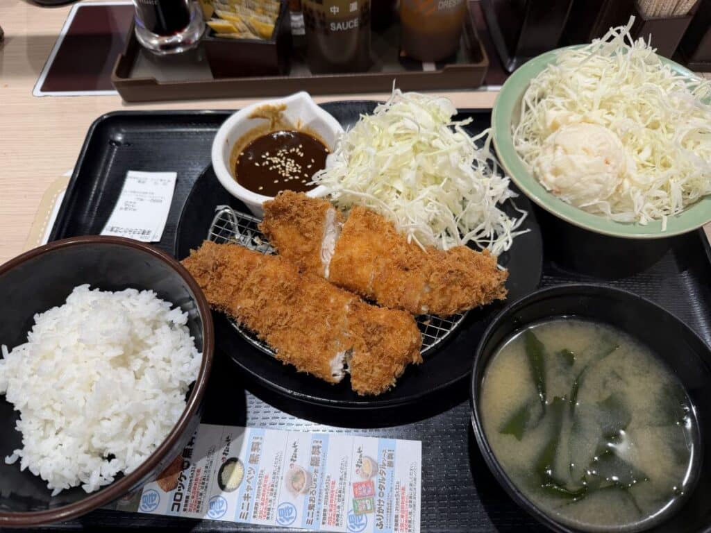 Set meal from a teishokyu restaurant in Japan with breaded pork cutlet, rice, miso, shredded cabbage and a side of potato salad