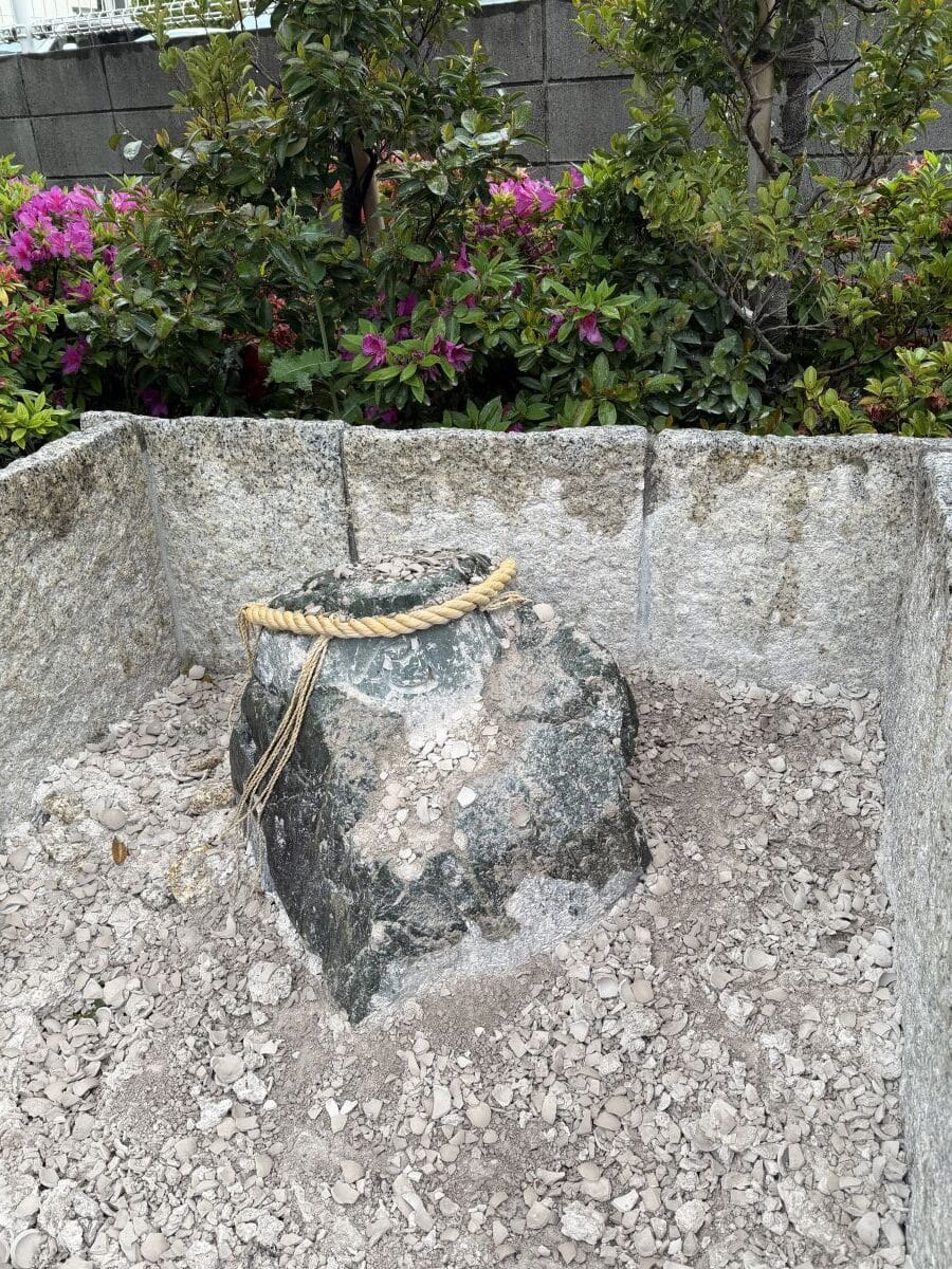Large grey rock with a rope tied around the top