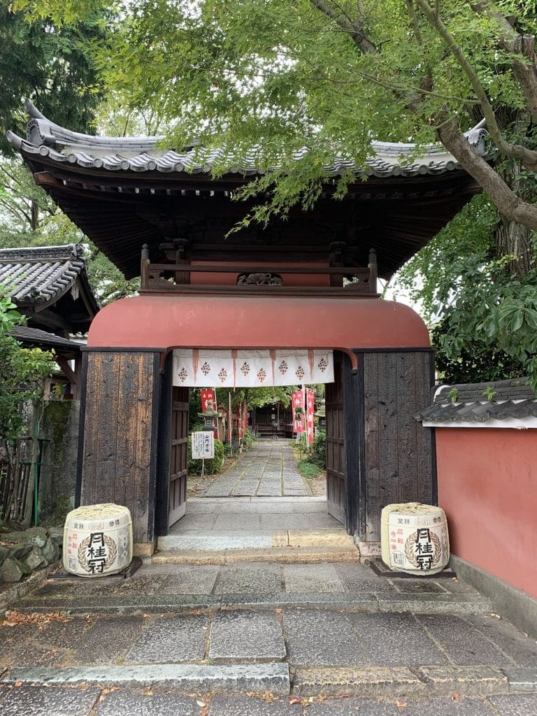 front gate at Choken-ji temple in Fushimi showing the wooden gate with sake barrels either side
