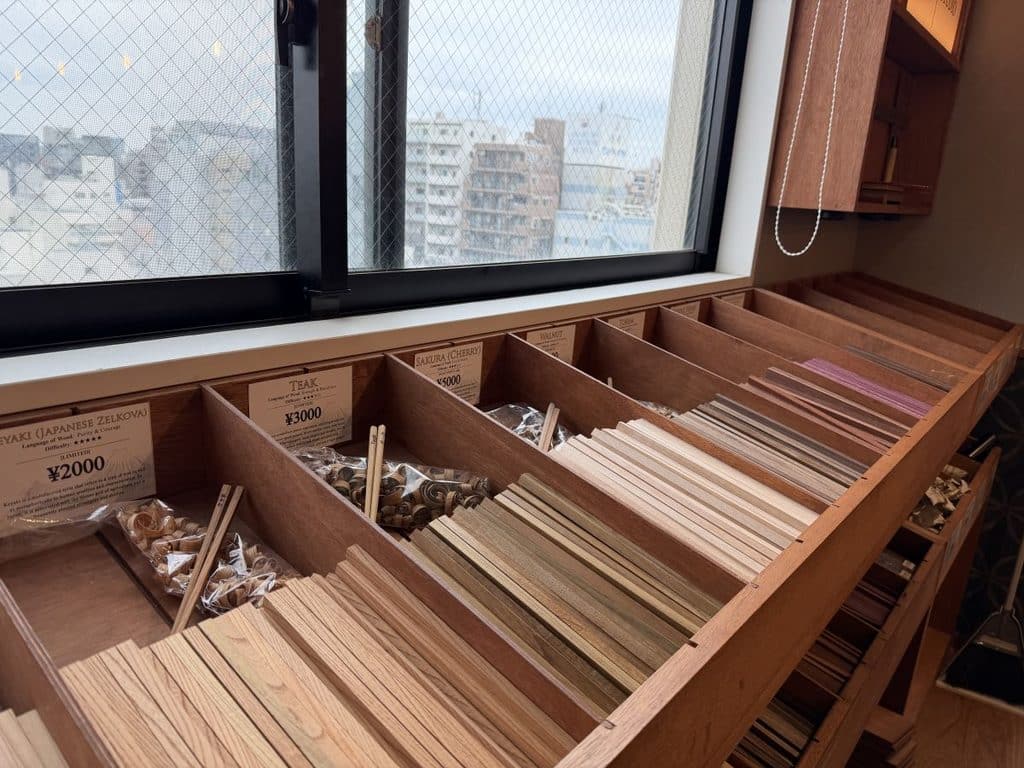 row of sticks in different woods that you can choose from to make chopsticks in Asakusa
