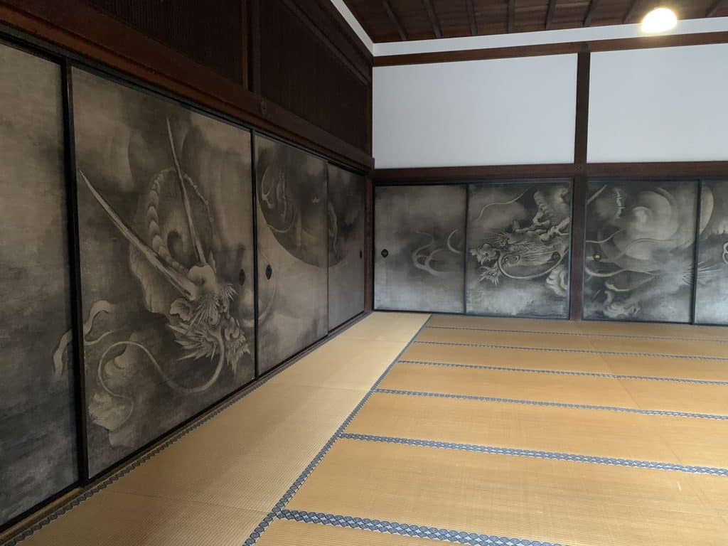 Tatami mat room. The walls are lined with screens showing a black and white painting of dragons