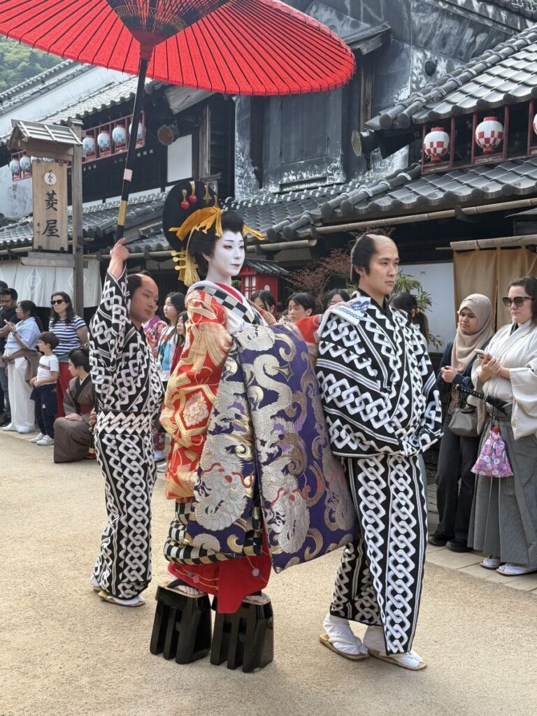 Oiran balances on her assistant during the oiran walk at Edo Wonderland