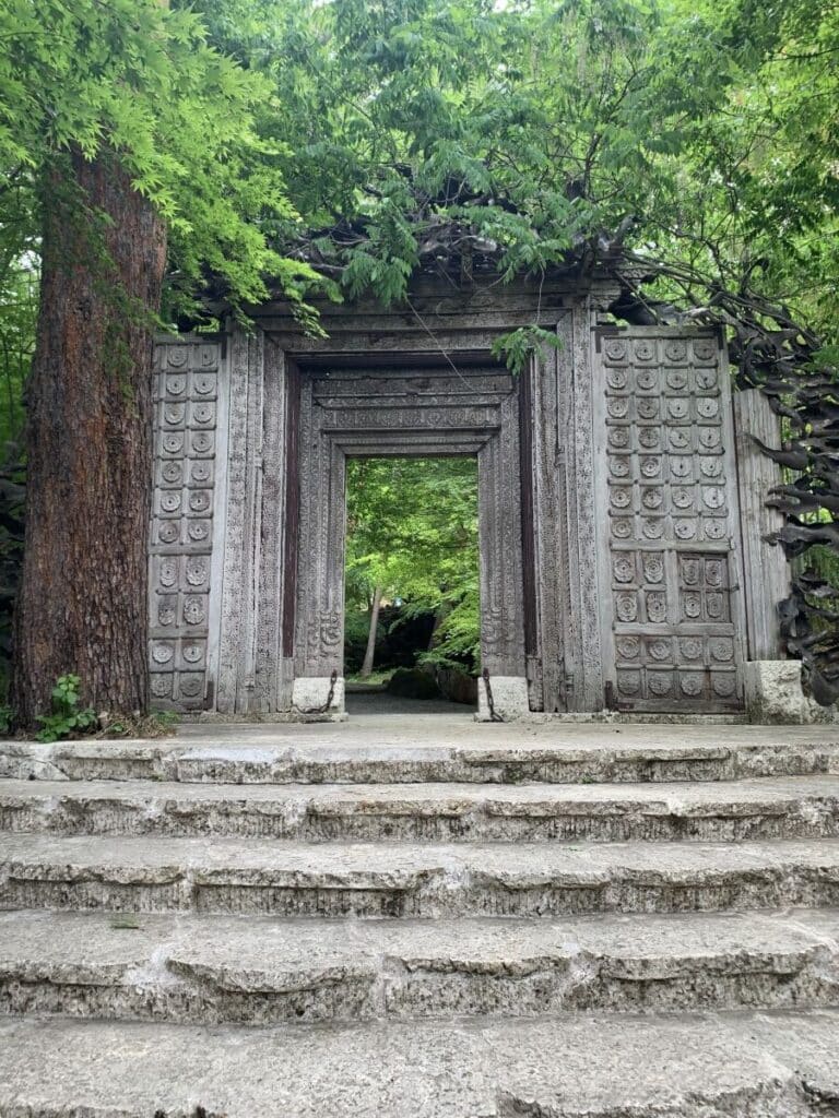 Ornate entry gate to the Kubota Itchiku Art Museum in Kawaguchiko. It looks like something from a temple in Cambodia, big stone carved gates with trees growing all over it.