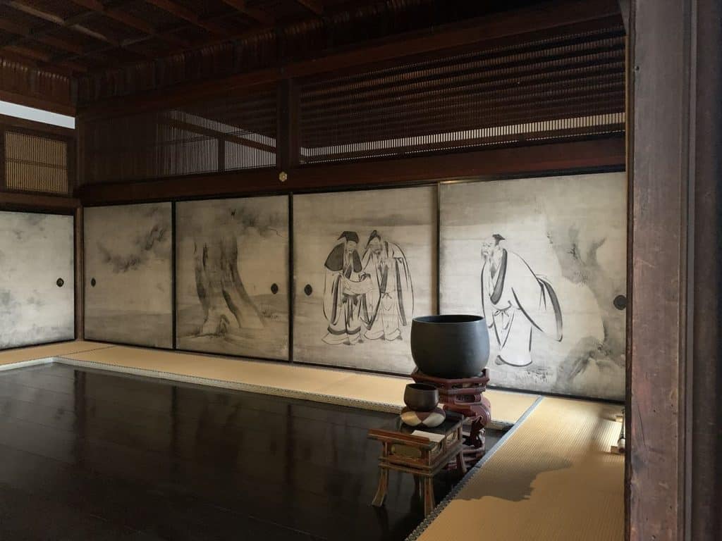 Room line with screen paitings of old men in long robes